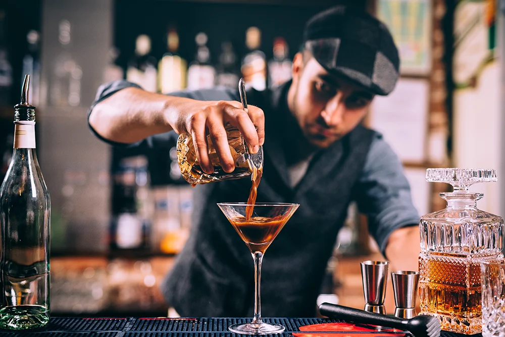 A bartender pours an espresso martini